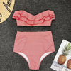 Red and white striped bikini set on a dark textured surface with a pineapple-themed card.