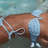 Person wearing a light blue bikini in clear water