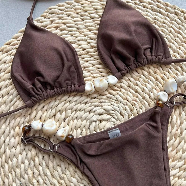 Brown bikini set with matching face mask on a woven surface