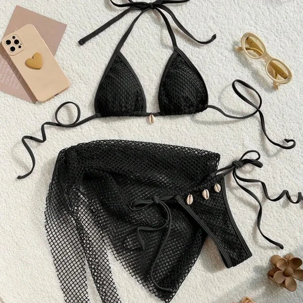 Black bikini set with matching cover-up on a textured surface.