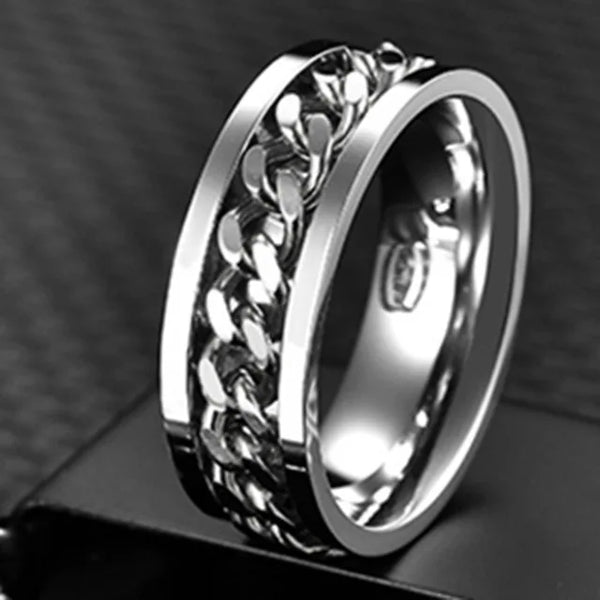Silver ring with intricate design on a dark background