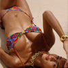 Woman wearing a colorful bikini lying on sand