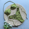 Green bikini set on a woven mat with flowers on a blue background