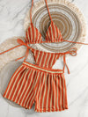 Striped bikini set with ruffled details on a decorative plate