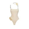 Beige one-piece swimsuit with floral details on a white background