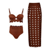 Brown bikini set and patterned skirt on a white background