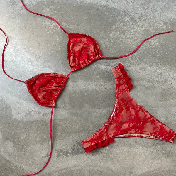 Red bikini set on a textured gray surface