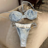 Denim bikini set on a beige surface with a neutral background