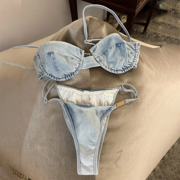 Denim bikini set on a beige surface with a neutral background