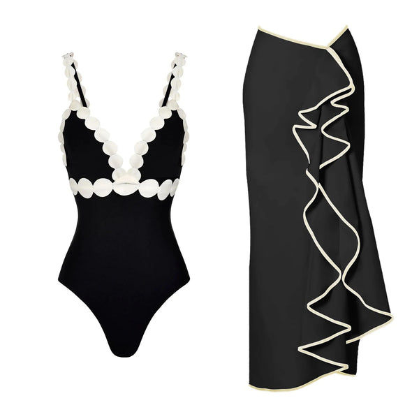 Black swimsuit with white scalloped edges and black skirt with white trim on a white background