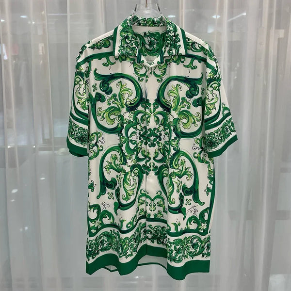 Green and white patterned shirt on a hanger against a light curtain background