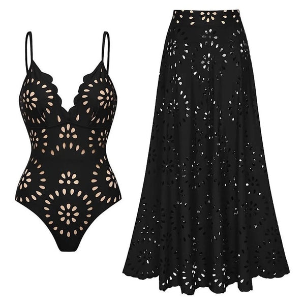 Black swimsuit with cut-out design and matching black skirt on a white background