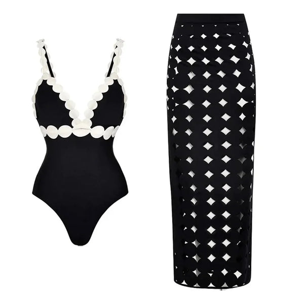 Black swimsuit with white accents and black skirt with geometric pattern on a white background