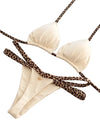 Beige bikini set with leopard print straps on a gray surface, featuring a brand tag.