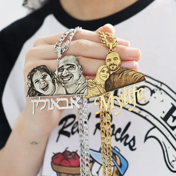 Two necklaces with engraved images of a couple, one silver and one gold, held by a person.
