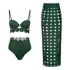 Green bikini set and green skirt with geometric pattern on a white background