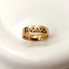 Rose gold ring with engraved name on a light gray background