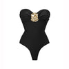 Black swimsuit with a gold embellished bow on a white background