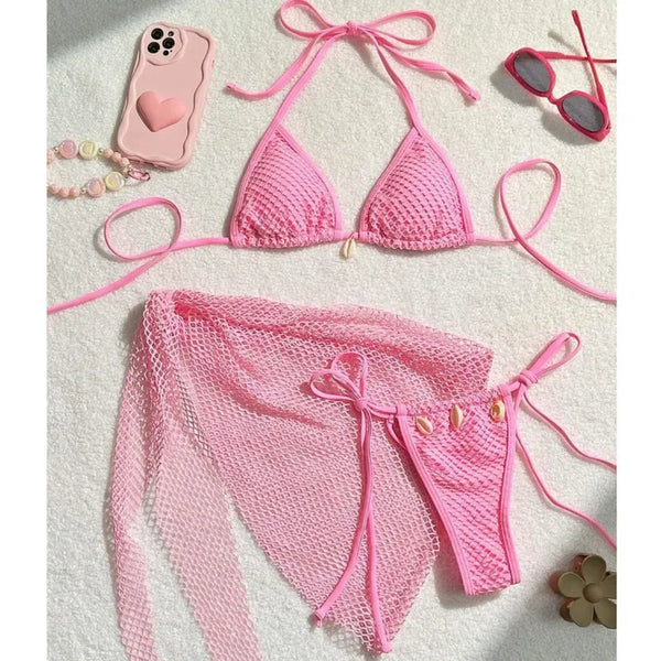 Pink bikini set with matching accessories on a light background