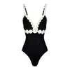 Black swimsuit with white scalloped edges on a white background