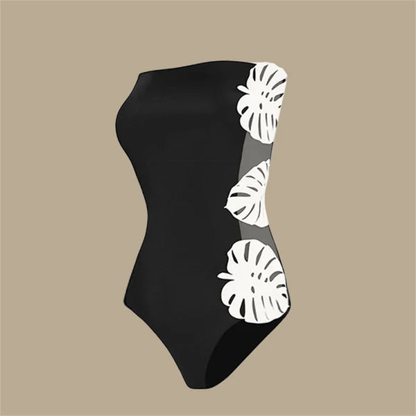 Black swimsuit with white leaf patterns on a beige background