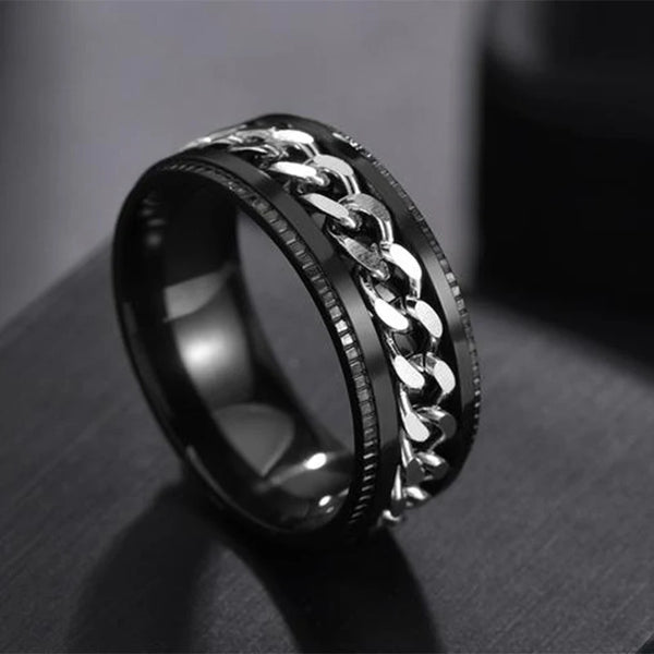 Black and silver chain ring on a dark surface