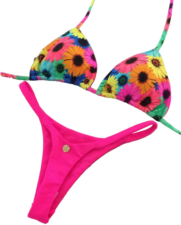 Colorful floral bikini top and pink bottom on a decorative mat with a brand tag.