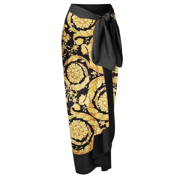 Black and gold patterned skirt with a tie waist on a white background