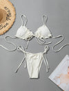 White bikini set with matching straps on a gray background