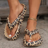 Leopard print sandals worn on feet with a blurred background