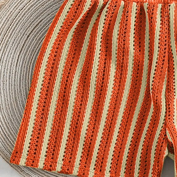 Close-up of a ball of yarn with orange and beige stripes.