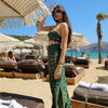 Woman in a green dress on a beach with umbrellas and ocean view