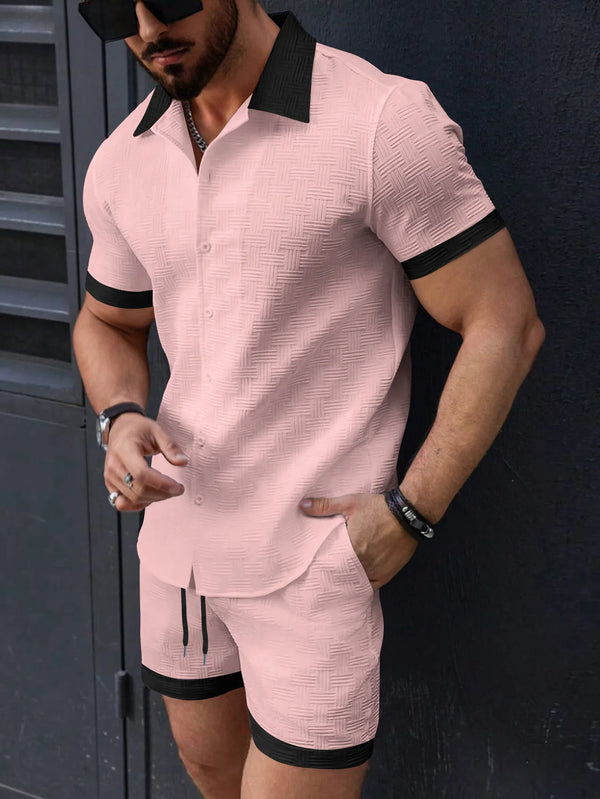 Man wearing a pink textured outfit with black accents against a dark background