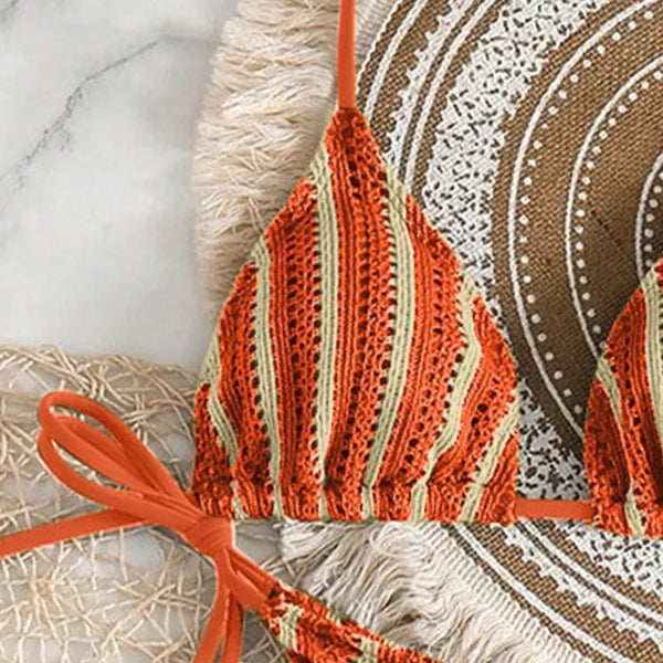 Orange and beige striped bikini top on a textured surface