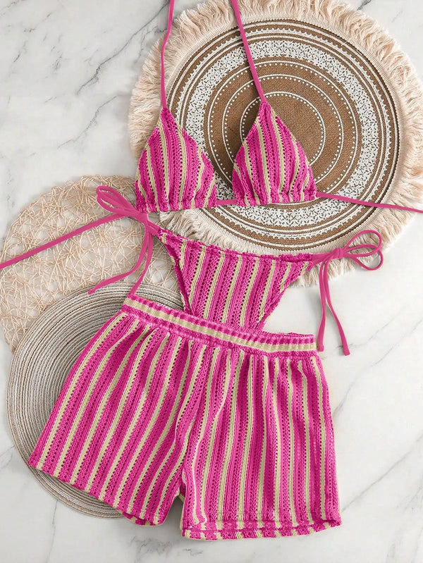 Pink and white striped bikini set on a marble surface
