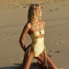Woman in a yellow swimsuit on a sandy beach