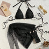 Black bikini set with matching cover-up on a textured surface.