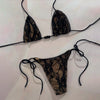 Black lace bikini set on a light pink background