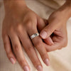 Close-up of hands with a silver ring on a beige background