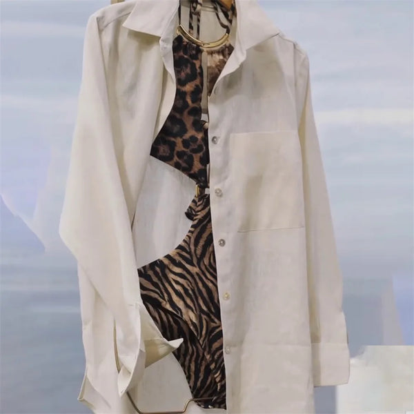 Beige trench coat with leopard print lining on a blurred sky background