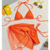Orange bikini set on a white surface with a phone and sunglasses.