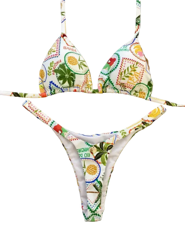 Colorful bikini set with floral and fruit patterns on a decorative stand.