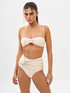 Woman wearing a beige bikini set on a white background