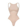 Beige bodysuit with thin straps on a white background