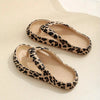 Pair of leopard print slippers on a beige background