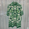 Green and white patterned shirt on a hanger against a light curtain background