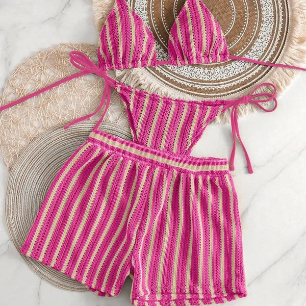 Pink and yellow striped romper on a textured surface