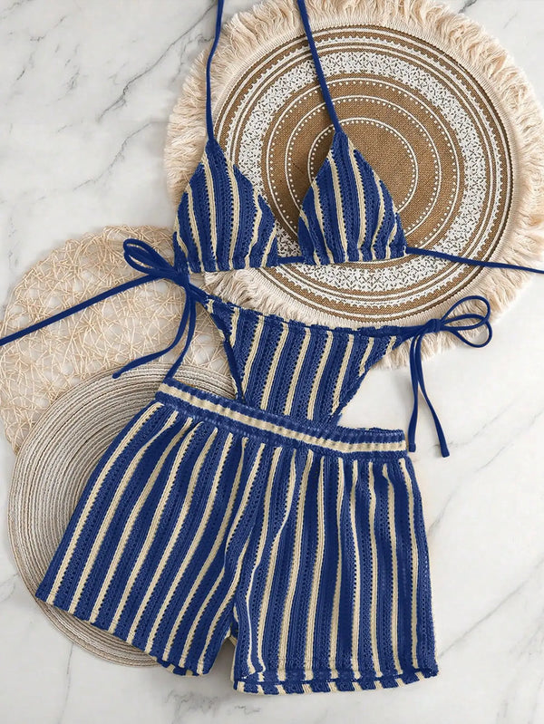 Blue and white striped bikini set on decorative plates with a marble background