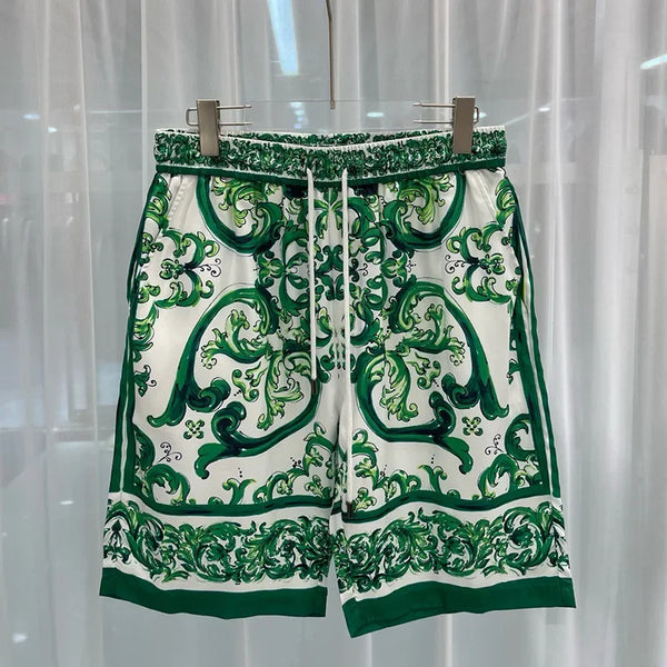Green and white patterned shorts on a hanger against a white curtain background